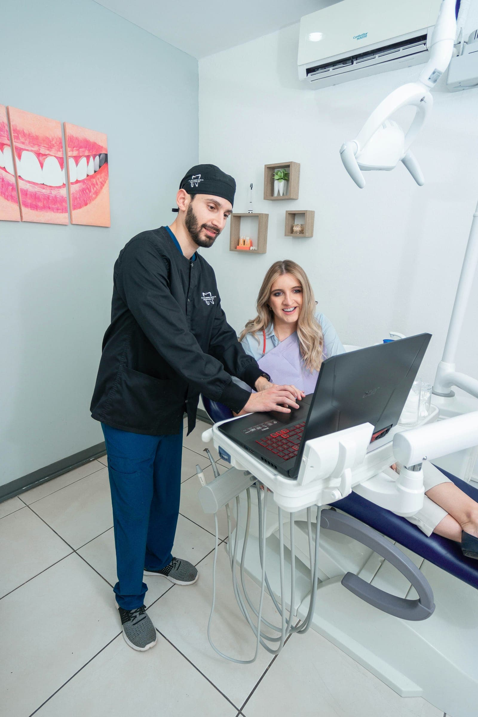 Dentista mostra o planejamento na tela do computador para uma paciente na cadeira odontológica.
